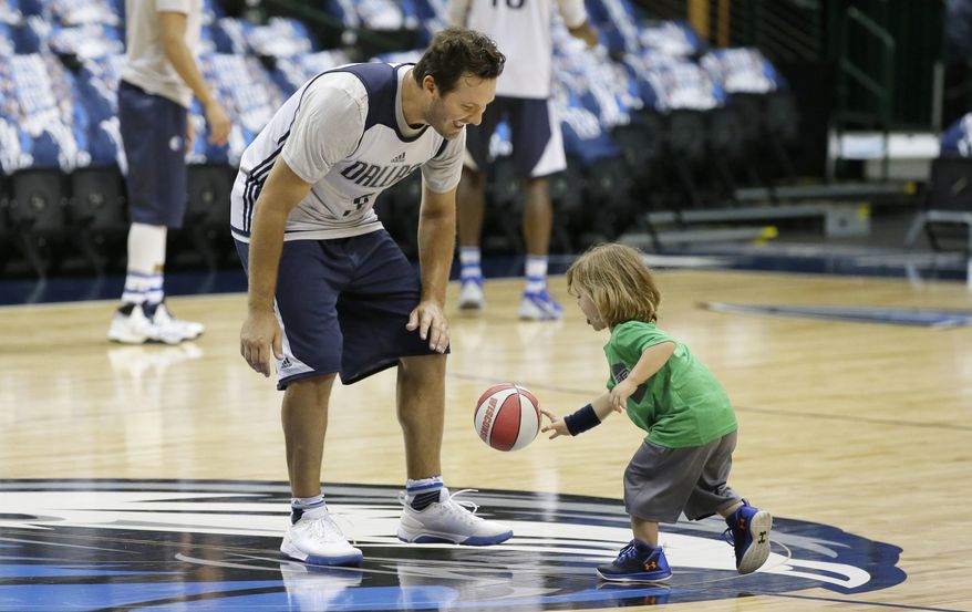 Former Dallas Cowboys quarterback Tony Romo, left, plays with his son, Rivers Romo, after a Dallas Mavericks morning NBA basketball shoot around in Dallas, Tuesday, April 11, 2017. Romo will be a Maverick for day and ride the bench when the team plays the Denver Nuggets in a home finale featuring two teams that failed to make the playoffs this year. (AP Photo/LM Otero)