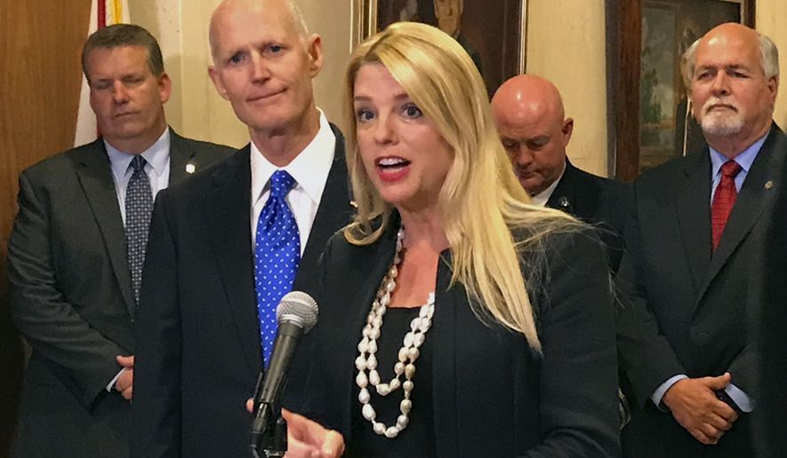 Florida Attorney General Pam Bondi speaks as Florida Gov. Rick Scott, second from left, listens during a news conference at the state capitol on Tuesday, April 11, 2017, in Tallahassee, Fla. (AP Photo/Joe Reedy)