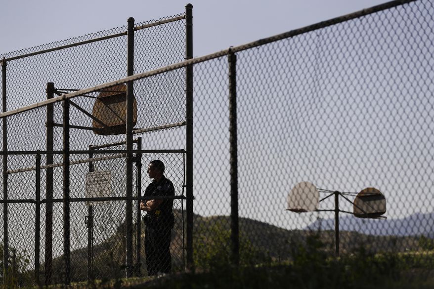 A police officer stands guard at North Park Elementary School, Monday, April 10, 2017, in San Bernardino, Calif. A husband opened fire on his wife Monday at the elementary school classroom, in a deadly shooting that spread panic across a city still recovering emotionally from a terrorist attack at a community center just 15 months ago. (AP Photo/Jae C. Hong)