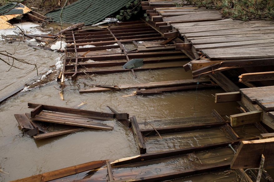 The covered bridge at Tyler Creek Golf Course and Campground lays partially in the creek off of 92nd Street between Wingeier Avenue and Hastings Road in Alto, Mich., Tuesday, April 11, 2017. Authorities say severe thunderstorms Monday night spawned a suspected tornado in western Michigan, knocking down a barn and blocking roadways with debris. (Neil Blake/The Grand Rapids Press via AP)