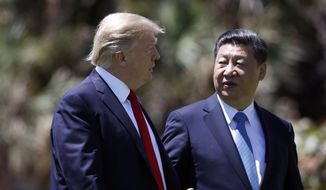 President Donald Trump, left, and Chinese President Xi Jinping walk together after their meetings at Mar-a-Lago, in Palm Beach, Fla., in this April 7, 2017, file photo. (AP Photo/Alex Brandon, File)