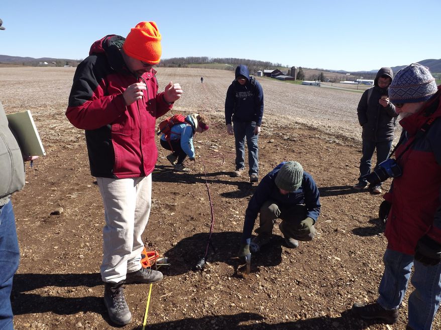 In this Saturday, April 8, 2017, Professor Ryan Mathur, left, prepares geological equipment to search for old lead mines with other geologists and Juniata College students in a field in Tyrone Township, Pa. The students prepared days earlier by plotting out possible sites for the search. (Ryan Brown /Altoona Mirror via AP)
