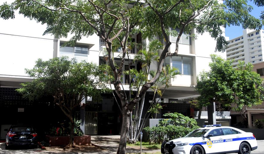A police car sits outside an apartment building where human remains were found in Honolulu's Waikiki neighborhood, Wednesday, April 12, 2017. Police arrested a 26-year-old man Tuesday on suspicion of second-degree murder after human remains were found in his Waikiki apartment. (AP Photo/Jennifer Sinco Kelleher)