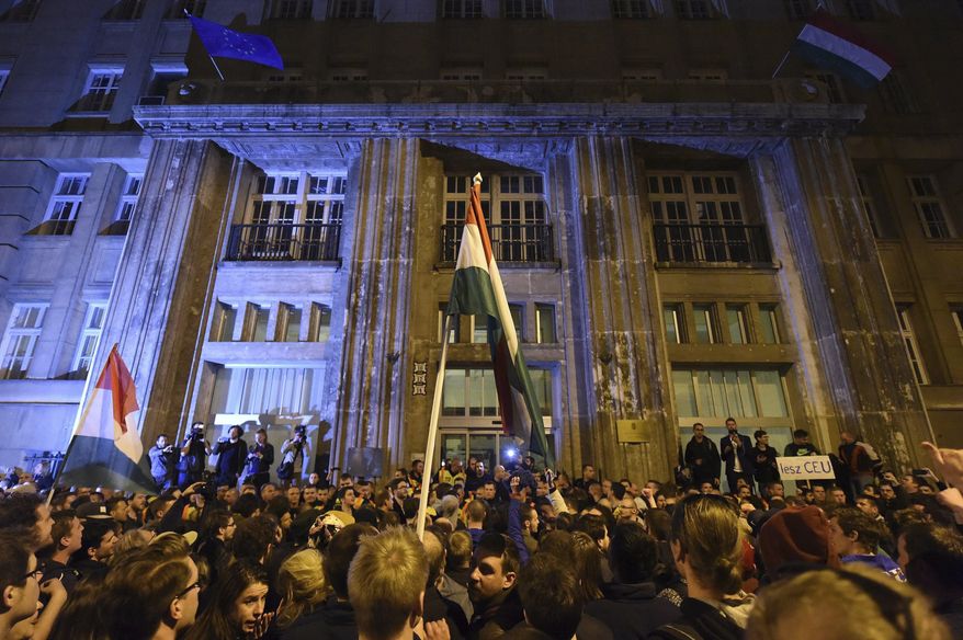 Demonstrators chant slogans during a protest against the amendment of the higher education law that could force a Budapest university founded by billionaire American philanthropist George Soros to close, in front of the Ministry of Human Resources, in Budapest, Sunday, April 9, 2017. Hungarian President Janos Ader said Monday April 10, 2017, in a statement that he has signed the bill setting new conditions for foreign universities in Hungary in line with the Constitution, and called on the government to “immediately” begin talks with the affected institutions to secure compliance with the new rules.(Zoltan Balogh/MTI via AP)