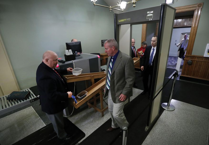 In this Tuesday, April 11, 2017, photo, Iowa Capitol security officer Gerri McCurdy, left, talks with a visitor entering the Statehouse, in Des Moines, Iowa. Iowa could soon allow anyone entering its state Capitol building to be armed, a move that mirrors a growing number of statehouses around the country but one that also raises security logistics. (AP Photo/Charlie Neibergall)