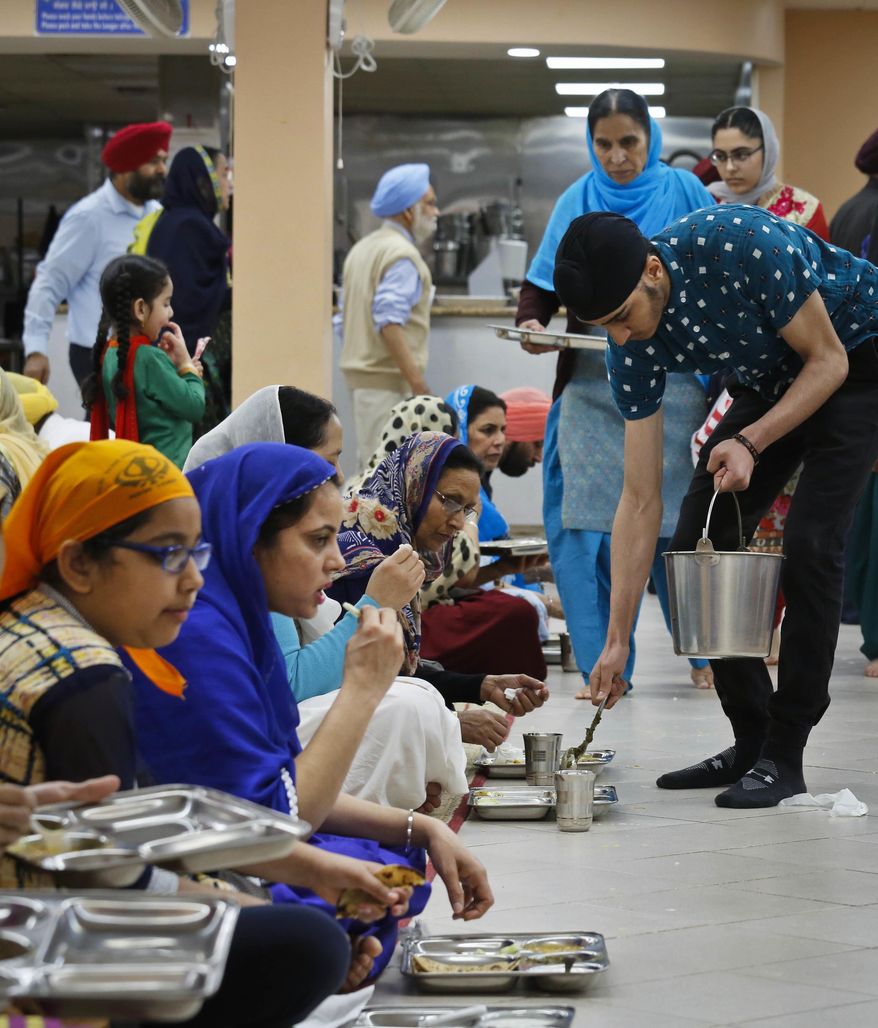 In this April 9, 2017 photo, Sikh congregants and visitors share in a Sikh community meal served free to anyone regardless of faith, religion or background, at the Guru Nanak Darbar house of worship in Hicksville, N.Y. The Long Island Sikh community has escaped much of the violence that has plagued Sikhs elsewhere, but America's Sikh community is launching a million-dollar nationwide public awareness campaign to help prevent hate attacks against its people. (AP Photo/Bebeto Matthews)