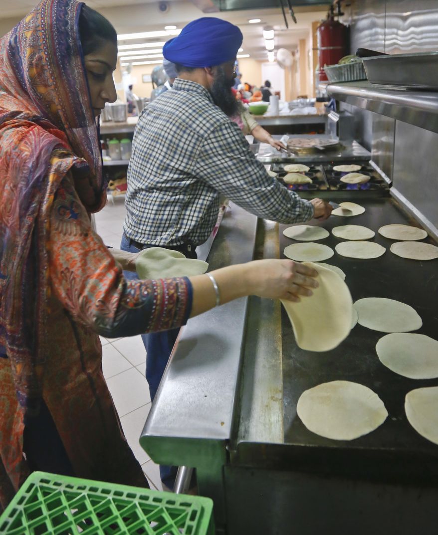 In this April 9, 2017 photo, men and women prepare roti flat bread for a Sikh community meal served free to anyone regardless of faith, religion or background, at the Guru Nanak Darbar house of worship in Hicksville, N.Y. The Long Island Sikh community has escaped much of the violence that has plagued Sikhs elsewhere, but America's Sikh community is launching a million-dollar nationwide public awareness campaign to help prevent hate attacks against its people. (AP Photo/Bebeto Matthews)