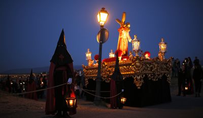 Hooded penitents from &quot;Jesus con la Cruz a Cuestas&quot; brotherhood hold lanterns with candles they take part in a traditional annual Holy Week procession in Segovia, Spain, Thursday, April 13, 2017. Hundreds of processions take place throughout Spain during the Easter Holy Week. (AP Photo/Francisco Seco)