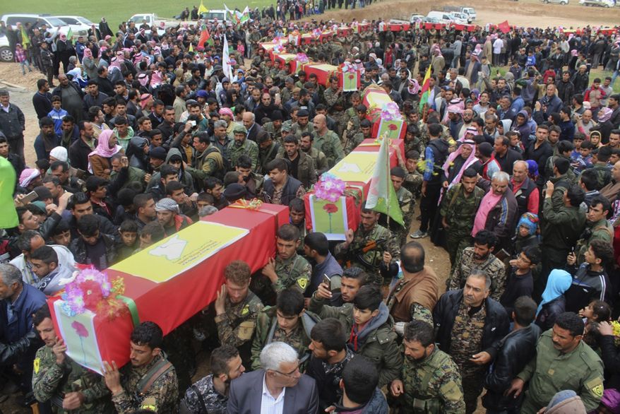 This photo provided by Hawar News Agency, a Kurdish-run news agency, which has been authenticated based on its contents and other AP reporting, shows fighters from the predominantly-Kurdish Syrian Democratic Forces carrying the coffins of their comrades, who were killed Tuesday by a misdirected airstrike by the U.S.-led coalition, during their funeral procession, in Tal al-Abyad, northeast Syria, Thursday, April 13, 2017. U.S. Central Command said coalition aircraft were given the wrong coordinates by their partner forces, the Syrian Democratic Forces, for a strike intended to target Islamic State militants south of their Tabqa stronghold. (Hawar News Agency via AP)