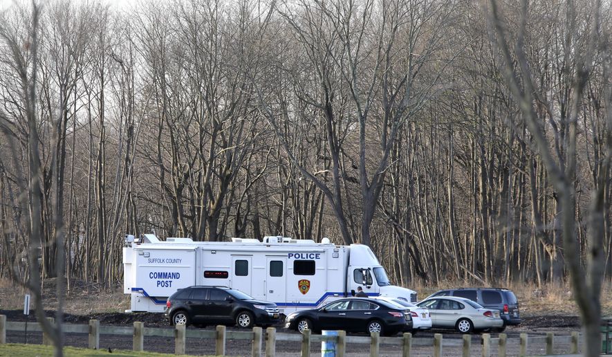 Emergency vehicles are parked near the site where four bodies were discovered in Central Islip, N.Y., Thursday, April 13, 2017. Police say the bodies of four apparent homicide victims have been found in a Long Island park, east of New York City. (AP Photo/Seth Wenig)
