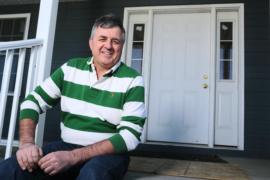 In this March 17, 2017 photo, Larry Shimmin, who heads the Building Trades program at United Township High School, poses for a photo in front of a student-built house in Silvis, Ill. The students had help from electricians, plumbers and other builders when they needed specific expertise or equipment the program does not possess, but otherwise, did much of the work. (Brian Achenbach/The Dispatch via AP)