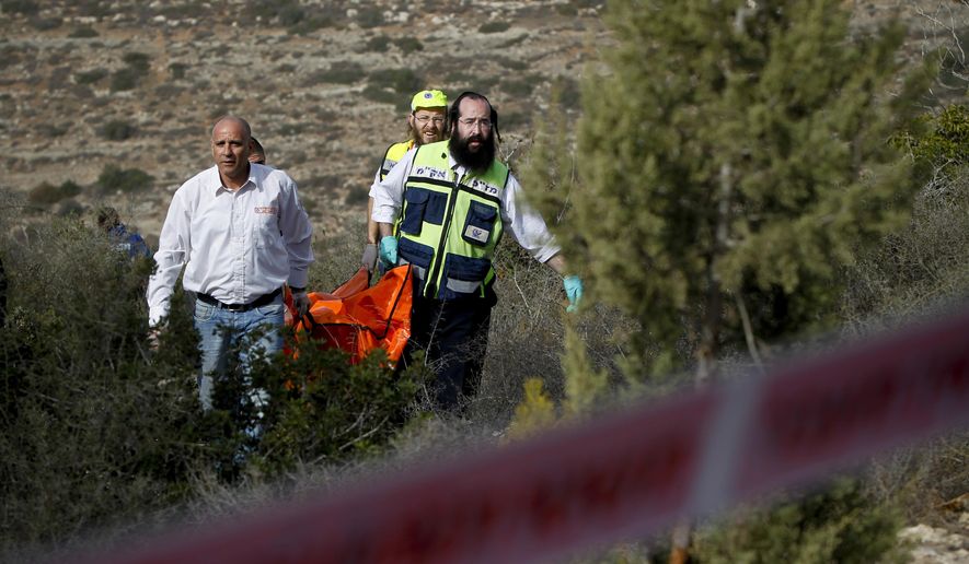 FILE - In this Dec. 19, 2010 file photo, Israeli rescue workers carry the body of U.S. tourist Kristine Luken after she was found in a wooded area near the village of Mata, outside Jerusalem. Two Palestinian men convicted in Israel of murdering Luken who was hiking near an Israeli archaeological site could face charges in the U.S. if they're ever released from an Israeli prison. (AP Photo/Tara Todras-Whitehill, File)