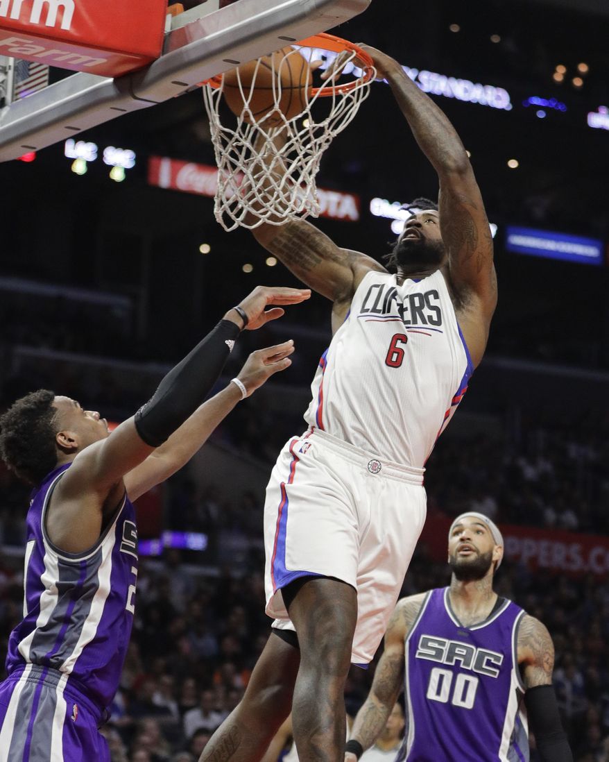 Los Angeles Clippers' DeAndre Jordan dunks as Sacramento Kings' Buddy Hield, left, and Willie Cauley-Stein watch during the second half of an NBA basketball game Wednesday, April 12, 2017, in Los Angeles. The Clippers won 115-95. (AP Photo/Jae C. Hong)