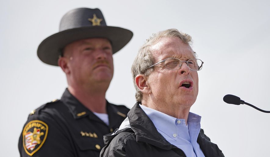 FILE – In this April 27, 2016, file photo, Ohio State Attorney General Mike DeWine, right, speaks to reporters alongside Pike County Sheriff Charles Reader, left, during a news conference in Waverly, Ohio. DeWine and Reader planned a news conference Thursday, April 13, 2017, about the unsolved killings of seven adults and a teenage boy from the Rhoden family whose bodies were found at four homes near Piketon, Ohio, on April 22, 2016, as the anniversary of the massacre approaches. (AP Photo/John Minchillo, File)