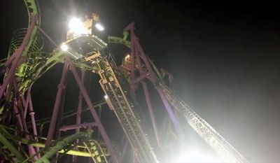 In this image made from a video provided by the Prince George’s County Fire Department, firefighters respond to the scene after over a dozen people became stuck when a roller coaster stalled at Six Flags on Thursday, April 13, 2017, in Largo, Md. (Prince George’s County Fire Department via AP)