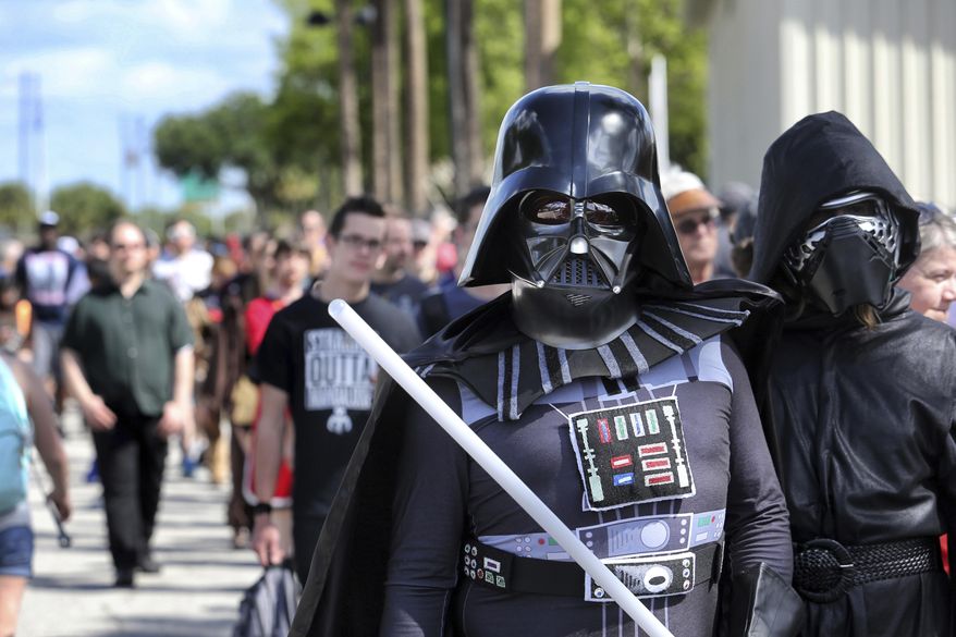 Costumed fans of the Star Wars franchise wait in a massive line outside the Orange County Center, in Orlando, Fla., to attend the 2017 Star Wars Celebration, Thursday, April 13, 2017, marking the 40th anniversary of the original 1977 Star Wars film. Thousands of fans waited for hours in the line, estimated to be more than a mile long. (Joe Burbank/Orlando Sentinel via AP)