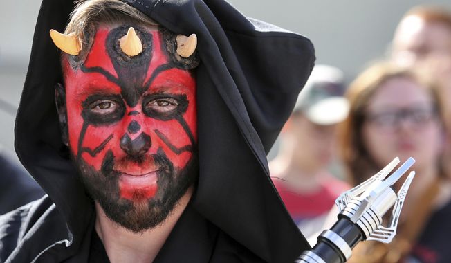 Costumed fans of the Star Wars franchise wait in a massive line outside the Orange County Center, in Orlando, Fla., to attend the 2017 Star Wars Celebration, Thursday, April 13, 2017, marking the 40th anniversary of the original 1977 Star Wars film. Thousands of fans waited for hours in the line, estimated to be more than a mile long. (Joe Burbank/Orlando Sentinel via AP)
