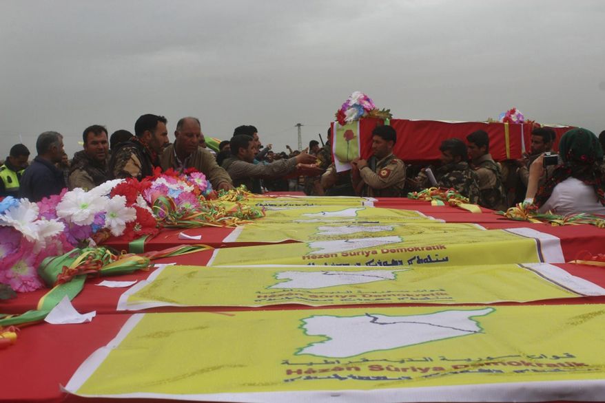 This photo provided by Hawar News Agency, a Kurdish-run news agency, which has been authenticated based on its contents and other AP reporting, shows fighters from the predominantly-Kurdish Syrian Democratic Forces carrying the coffins of their comrades, who were killed Tuesday by a misdirected airstrike by the U.S.-led coalition, during their funeral procession, in Tal al-Abyad, northeast Syria, Thursday, April 13, 2017. U.S. Central Command said coalition aircraft were given the wrong coordinates by their partner forces, the Syrian Democratic Forces, for a strike intended to target Islamic State militants south of their Tabqa stronghold. (Hawar News Agency via AP)