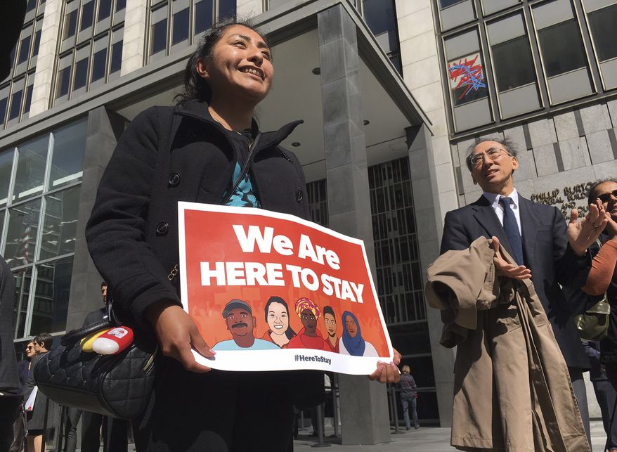 Erica Leyva with the Services, Immigrant Rights and Education Network of San Jose, California, carries a message outside a courthouse in San Francisco where a federal judge heard arguments in a lawsuit challenging President Trump's executive order to withhold funding from communities that limit cooperation with immigration authorities. (Associated Press/File)