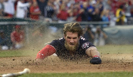 Washington Nationals&#39; Bryce Harper slides home to score the winning run on a hit by Daniel Murphy during the tenth inning of a baseball game against the Philadelphia Phillies, Friday, April 14, 2017, in Washington. (AP Photo/Nick Wass)