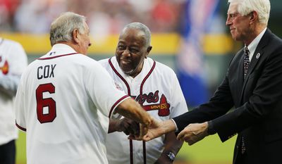 Former Atlanta Braves&#x27; Hank Aaron, center, talks with former manager Bobby Cox, left, after throwing Cox the ceremonial first pitch before a baseball game between the Braves and the San Diego Padres as Chairman and CEO Terry McGuirk, right, looks on in Atlanta, Friday, April 14, 2017. The Braves are playing their first regular-season game in SunTrust Park, the new suburban stadium that replaced Turner Field. (AP Photo/John Bazemore)