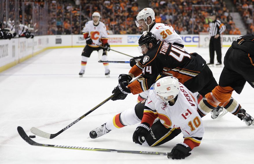 Anaheim Ducks&#x27; Nate Thompson, center, fights for the puck with Calgary Flames&#x27; Troy Brouwer, top, and Kris Versteeg during the first period in Game 1 of a first-round NHL hockey Stanley Cup playoff series Thursday, April 13, 2017, in Anaheim, Calif. (AP Photo/Jae C. Hong)