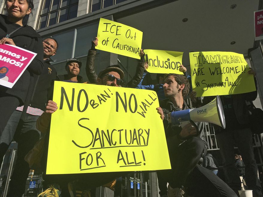Protesters hold up signs outside a courthouse where a federal judge will hear arguments in the first lawsuit challenging President Donald Trump&#39;s executive order to withhold funding from communities that limit cooperation with immigration authorities Friday, April 14, 2017, in San Francisco. U.S. District Court Judge William Orrick has scheduled a hearing on Friday on San Francisco&#39;s request for a court order blocking the Trump administration from cutting off funds to any of the nation&#39;s so-called sanctuary cities. (AP Photo/Haven Daley)
