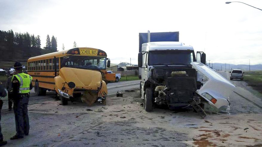 In this photo provided by the Washington State Patrol, emergency personnel work the scene of a crash involving a school bus and semi-truck Friday, April 14, 2017, near Colville, Wash. A student was taken to a hospital and several others suffered none life-threatening injuries in a crash involving a semi-truck and a school bus in eastern Washington state. Washington State Patrol Trooper Jeff Sevigney said that there were 25 elementary school students and a driver on the bus. (Washington State Patrol via AP)