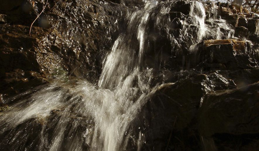 ADVANCE FOR THE WEEKEND OF APRIL 15-16 AND THEREAFTER - In a Thursday, April 6, 2017 photo, recent rain runoff increased the size of a waterfall flowing into Duck Creek behind Grant Auto Repair on State Street in Bettendorf, Iowa. The small Quad-City waterfall, revived by recent rains, has been featured in the top 10 "Wonderful Waterfalls" throughout the state on the website, Travel Iowa. (Kevin E. Schmidt/Quad City Times via AP)