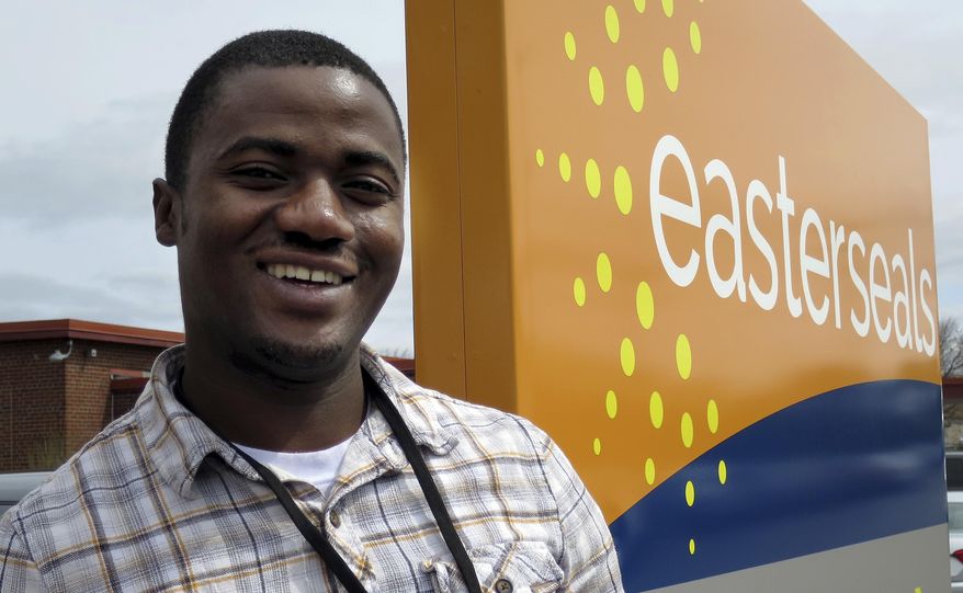 In this April 13, 2017 photo, Ombeni Kasongo poses outside the Easterseals office in Manchester, N.H. Kasongo, a native of the Democratic Republic of Congo, is among 11 immigrants and refugees being trained to work in a residential treatment facility for children with neurological, psychological and behavioral challenges. (AP Photo/Holly Ramer)