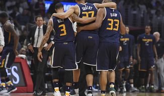 Utah Jazz center Rudy Gobert, center, is helped off the court by center Boris Diaw, right, and guard George Hill, left, as coach Quin Snyder watches after Gobert injured his knee during the first half in Game 1 of an NBA basketball first-round playoff series against the Los Angeles Clippers, Saturday, April 15, 2017, in Los Angeles. (AP Photo/Mark J. Terrill)