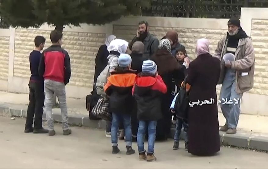 This frame grab from video provided by the government-controlled Syrian Central Military Media shows Syrian families gathering to leave in buses from Madaya, an opposition-held town near Damascus, Syria, Friday, April 14, 2017. The Syrian government and rebels began a coordinated population transfer Friday of about 10,000 people from four towns besieged for years amid the country's bloody, six-year civil war. (Syrian Central Military Media, via AP)