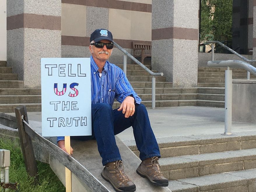 Mike Mannshardt, 70, a retired teacher from Pittsboro, N.C., waits to hear from speakers at an anti-Trump rally in Raleigh on Saturday, April 15, 2017. Mannshardt and other demonstrators want Trump to release his income tax returns. (AP Photo/ Emery P. Dalesio)