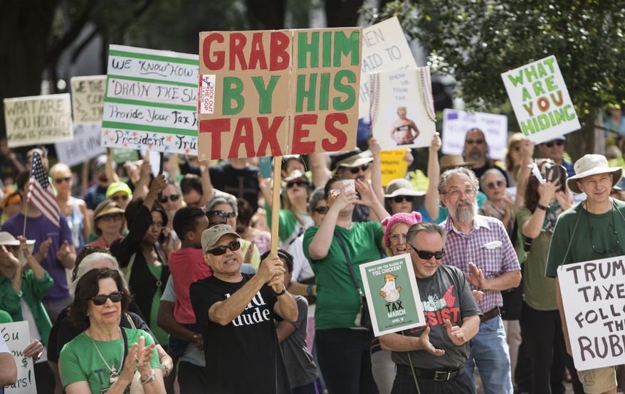 Demonstrators march through downtown Houston demanding greater governmental transparency and the release of President Donald Trump's tax returns during a protest Saturday, April 15, 2017. (Brett Coomer/Houston Chronicle via AP)