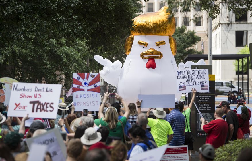 Demonstrators march through downtown Houston demanding greater governmental transparency and the release of President Donald Trump's tax returns during a protest Saturday, April 15, 2017. (Brett Coomer/Houston Chronicle via AP)