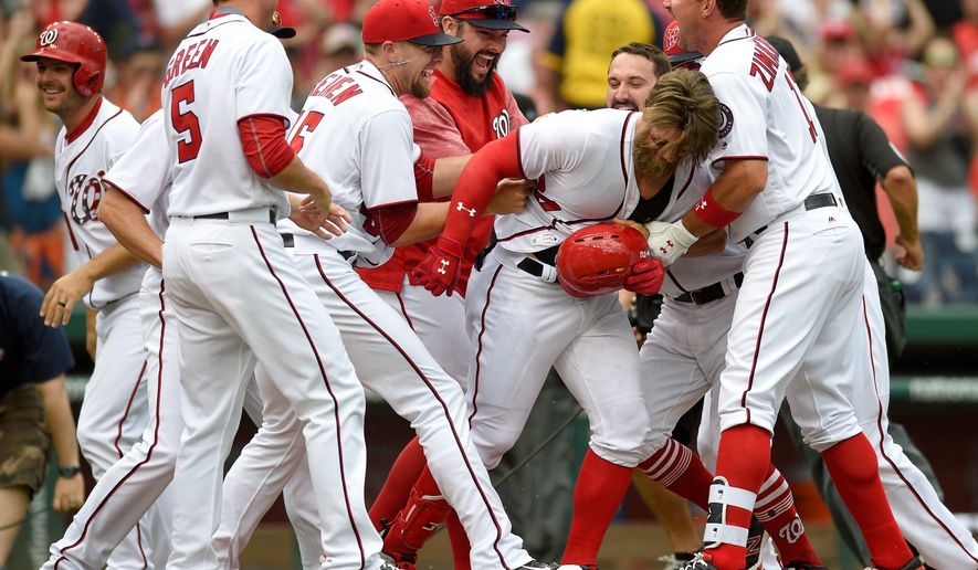 Washington Nationals&#39; Bryce Harper, second from right, is mobbed by teammates after a baseball game against the Philadelphia Phillies, Sunday, April 16, 2017, in Washington. Harper hit a three-run walkout home run. The Nationals won 6-4. (AP Photo/Nick Wass)