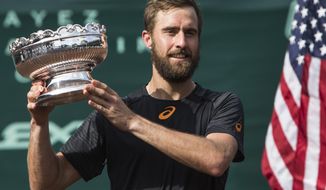Steve Johnson shows off the championship trophy after dfeating Thomaz Bellucci in the championship singles match of the U.S. Men&#39;s Clay Court Championship tennis tournament at River Oaks Country Club on Sunday, April 16, 2017, in Houston. Johnson won 6-4, 4-6, 7-6 (5), to take the title. ( Brett Coomer/Houston Chronicle via AP)