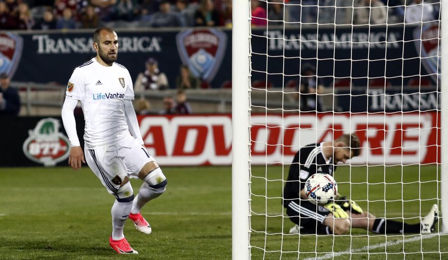 Real Salt Lake forward Yura Movsisyan, let, runs to the net to retrieve the ball after scoring a goal on a penalty kick past Colorado Rapids goalkeeper Zac MacMath in the second half of an MLS soccer match Saturday, April 15, 2017, in Commerce City, Colo. (AP Photo/David Zalubowski)