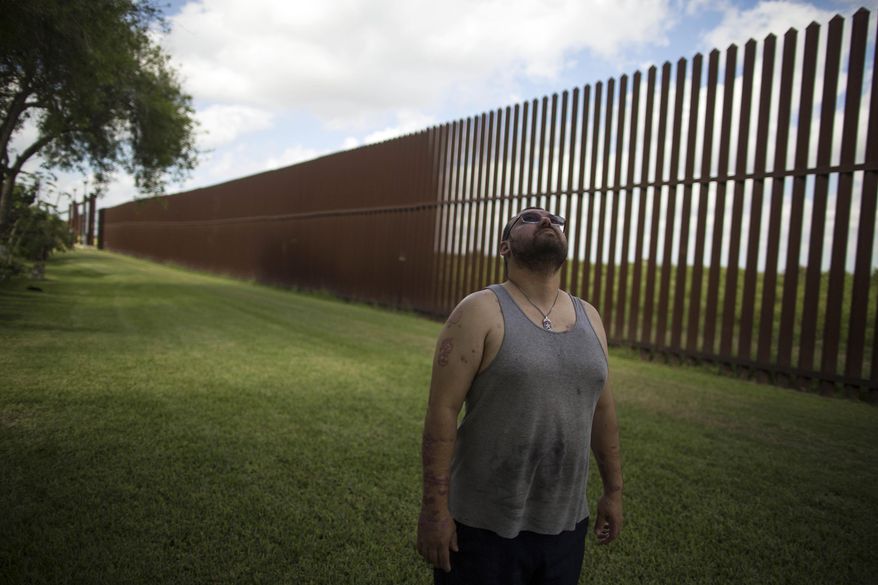 FILE - In this March 22, 2017, file photo, Antonio Reyes of Brownsville, Texas, stands by the U.S.-Mexico border fence near his home. Reyes said he's seen people scale the border fence that bisects his backyard and jump down in seconds. Sometimes they carry bales of what appear to be drugs. A higher wall is "still not going to stop them," he said. "They'll shotput it or whatever they have to do." (AP Photo/Rodrigo Abd, File)