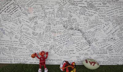 In this April 28, 2007, file photo, a memorial board sits under a tent with items that were placed in front of it, on the Drillfield on the Virginia Tech campus in Blacksburg, Va. Ten years after a mentally ill student fatally shot 32 people at Virginia Tech, survivors and families of the slain are returning to campus to honor the lives that were lost that day. Virginia Tech is holding a series of events Sunday, April 16, 2017, to mark the anniversary of the deadly campus shooting on April 16, 2007. (AP Photo/Alex Brandon, File)