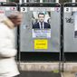 A man walks past electoral posters displaying the presidential candidates, Benoit Hamon, left, Emmanuel Macron, center, and Marine Le Pen in Paris, France, Monday, April 17, 2017. French centrist candidate Emmanuel Macron and far-right leader Marine Le Pen are hoping to bring in big crowds at competing rallies in Paris as the unpredictable race nears its finish. (AP Photo/Kamil Zihnioglu)