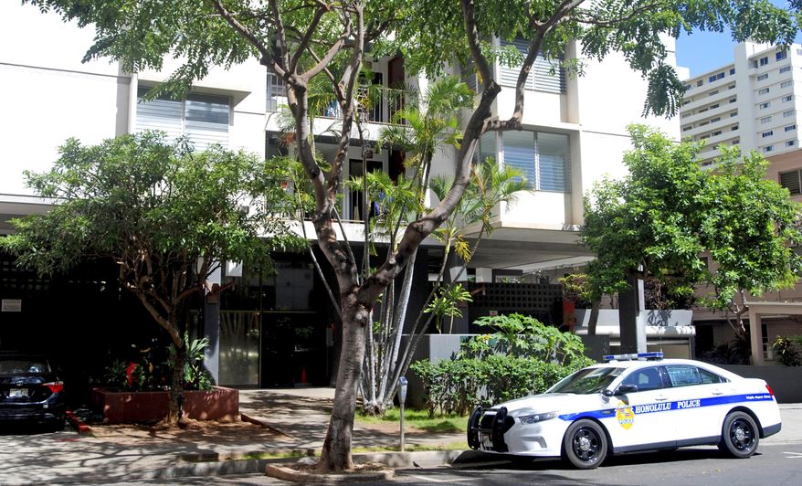 FILE - In this April 12, 2017 file photo, a Honolulu police car is parked outside an apartment building where human remains were found in the city's Waikiki neighborhood. A Hawaii man is accused of killing his mother and stuffing her decapitated head and body parts in seven plastic bags in the refrigerator freezer of the Waikiki apartment they shared. Yu Wei Gong has been charged with second degree murder. He was scheduled to make his initial appearance in court Monday, April 17, 2017. (AP Photo/Jennifer Sinco Kelleher, File)