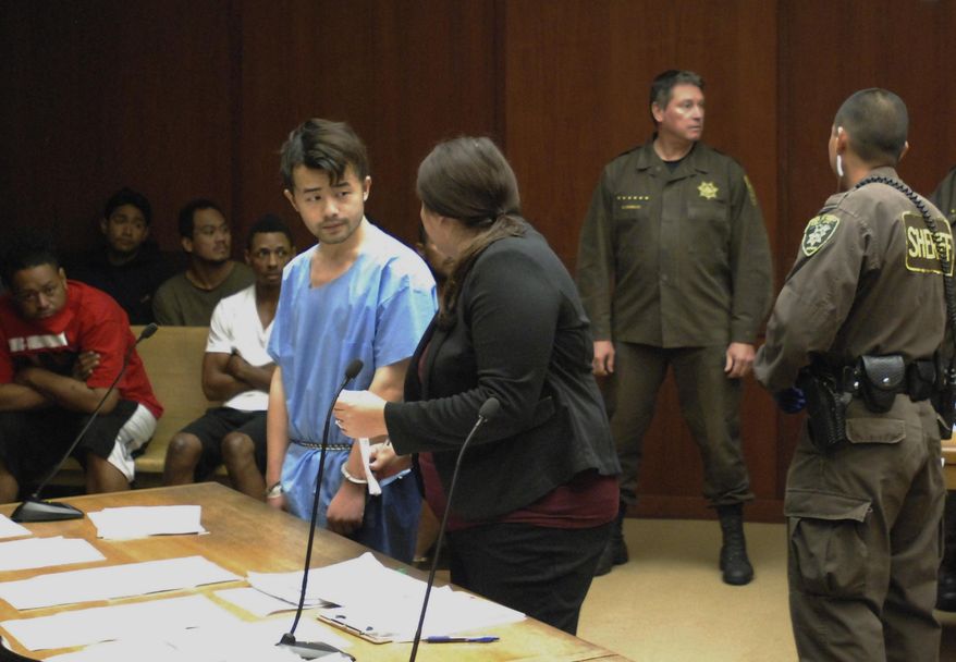 Yu Wei Gong, left, speaks to Deputy Public Defender Diamond Grace in court in Honolulu on Monday, April 17, 2017. The Hawaii man accused of killing his mother months ago stuffed her decapitated head and dismembered body parts in several plastic bags in the refrigerator freezer of the Waikiki apartment they shared, according to court documents made public ahead of the suspect's first court appearance. (AP Photo/Jennifer Sinco Kelleher)