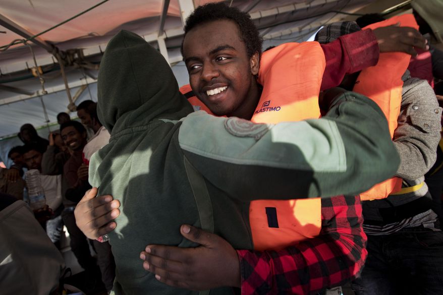 In this April 6, 2017 photo, a group of Eritreans migrants hug each other after meeting again abroad the Golfo Azurro rescue boat in the Mediterranean sea, about 56 miles north of Sabratha, Libya. The Eritreans, who sailed on two different boats, lost sight of each other soon after leaving the Libyan coast. The group reunited after being transferred to the Golfo Azurro. (AP Photo/Bernat Armangue)