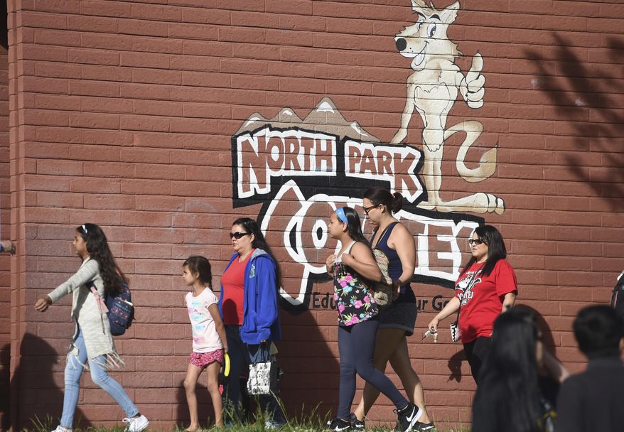 North Park Elementary students returned to school, Monday, April 17, 2017, a week after Cedric Anderson, 53, of Riverside, Calif., entered the campus with a gun, killing his estranged wife Karen Elaine Smith, 53, student Jonathan Martinez, 8, and wounding student Nolan Brandy, 9, before turning the gun on himself. (John Valenzuela /Los Angeles Daily News via AP)