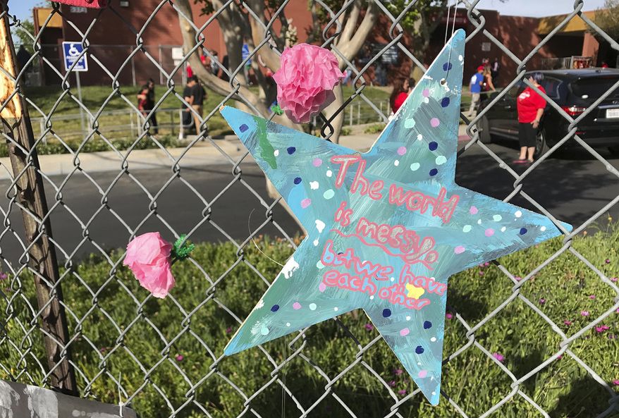 North Park Elementary students returned to school, Monday, April 17, 2017, a week after Cedric Anderson, 53, of Riverside, Calif., entered the campus with a gun, killing his estranged wife Karen Elaine Smith, 53, student Jonathan Martinez, 8, and wounding student Nolan Brandy, 9, before turning the gun on himself. (John Valenzuela /Los Angeles Daily News via AP)