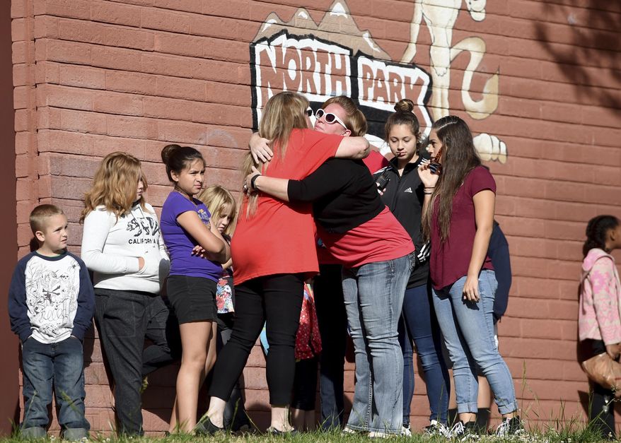 North Park Elementary students returned to school, Monday, April 17, 2017, in San Bernardino, Calif., a week after Cedric Anderson, 53, of Riverside, Calif., entered the campus with a gun, killing his estranged wife Karen Elaine Smith, 53, student Jonathan Martinez, 8, and wounding student Nolan Brandy, 9, before turning the gun on himself. (John Valenzuela /Los Angeles Daily News via AP)