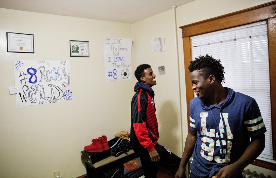 ADVANCE FOR USE WEDNESDAY, APRIL 19, 2017 AND THEREAFTER-Lewiston high school seniors and co-captains of the soccer team, Joseph Kalilwa, 18, right, and Abdiaziz Shaleh, 19, play in Kaliwa's room at his home in Lewiston, Maine, Tuesday, March 14, 2017. "I mean that kind of bothers me sometimes like when people you go everywhere they just see you as a refugee," said Kalilwa who was born in the Democratic Republic of Congo and is now an American citizen. "I'm like oh well, yeah, I am a refugee but then at the same time I see myself as an American." (AP Photo/David Goldman)