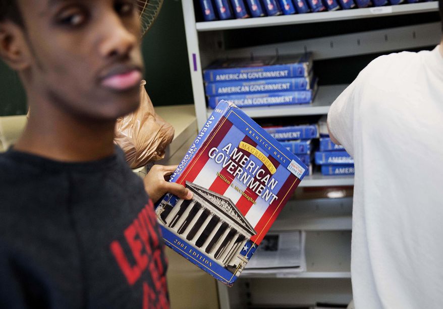 ADVANCE FOR USE WEDNESDAY, APRIL 19, 2017 AND THEREAFTER-Abdiaziz Shaleh, 19, a senior and co-captain of the soccer team, grabs a textbook off the shelf during his American government class at Lewiston High School in Lewiston, Maine, Wednesday, March 15, 2017. Shaleh, whose family is from Somalia, is graduating from high school soon and plans to go to prep school in Massachusetts to play soccer and to prepare for college. "I want to become something," he said, listing engineer, entrepreneur or a doctor as possibilities. "Anything that could be useful." (AP Photo/David Goldman)