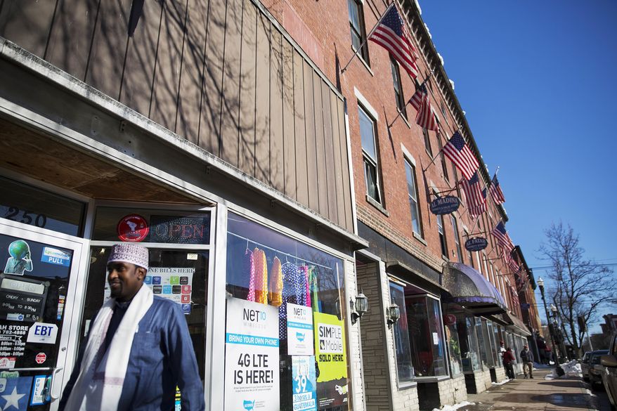 ADVANCE FOR USE WEDNESDAY, APRIL 19, 2017 AND THEREAFTER-U.S. flags hang outside a downtown building whose storefronts are made up of businesses started by African immigrants who have settled in Lewiston, Maine, Friday, March 17, 2017. Maine's immigrants from Sub-Saharan Africa made $136.6 million in income in 2014, and paid $40 million in taxes, according to a report from the New American Economy, a bi-partisan coalition pushing for immigration reform. (AP Photo/David Goldman)
